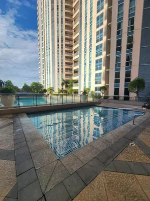 a swimming pool in front of two tall buildings at Modern Bright Cozy Stylish 1BR Venice BGC Balcony in Manila