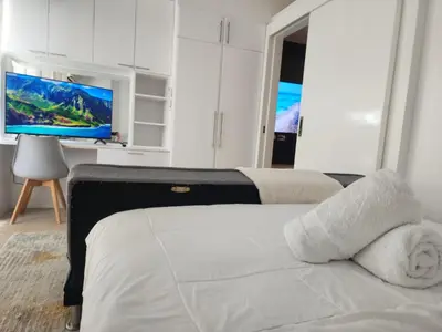 a bedroom with a bed and a flat screen tv at Modern Bright Cozy Stylish 1BR Venice BGC Balcony in Manila