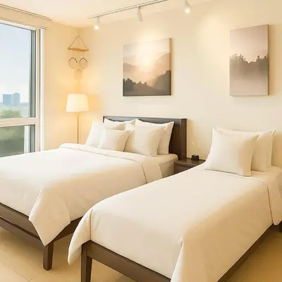 two beds sitting next to each other in a bedroom at Cozy & Spacious 2BR Stay Near BGC - Home Theater in Manila