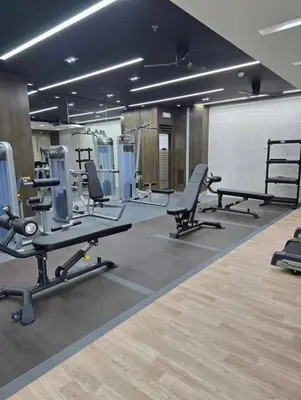 a gym with several treadmills and machines in a room at Red Residences Cozy Condo in Makati Near NAIA in Manila