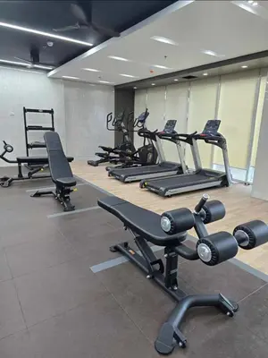 a gym with a row of treadms and cardio machines at Red Residences Cozy Condo in Makati Near NAIA in Manila