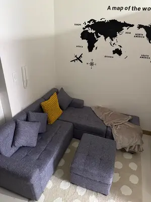 a living room with a couch and a map of the world at Red Residences Cozy Condo in Makati Near NAIA in Manila