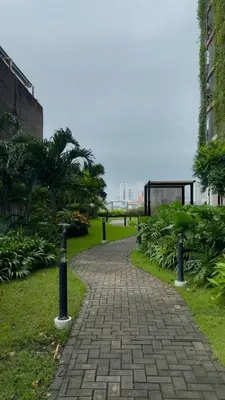 a brick path in a park with palm trees at Red Residences Cozy Condo in Makati Near NAIA in Manila