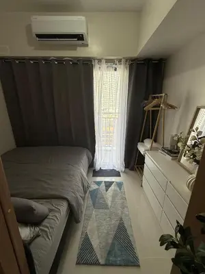 a small bedroom with a bed and a window at Red Residences Cozy Condo in Makati Near NAIA in Manila