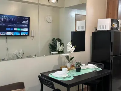 a dining room with a table with plates on it at JM's CRIB in Manila