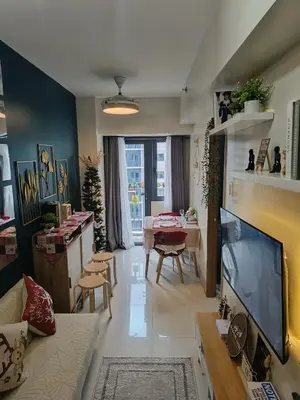 a living room with a tv and a dining room at SkyShore Suites in Manila