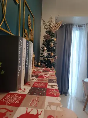a christmas table with a christmas tree in the background at SkyShore Suites in Manila