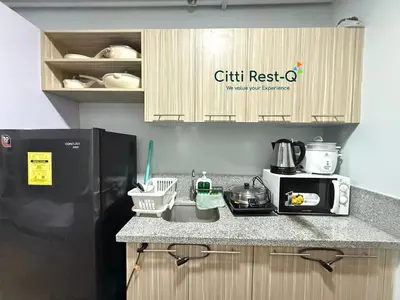 a kitchen with a sink and a black refrigerator at Studio City Alabang Pool Access Free for 2 Wifi & Netflix SC5 in Manila