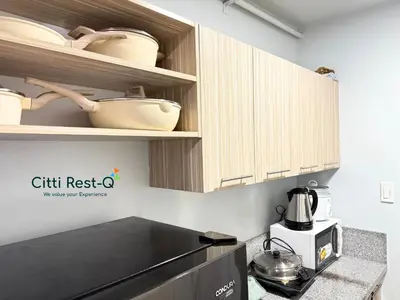 a kitchen with wooden cabinets and a counter top at Studio City Alabang Pool Access Free for 2 Wifi & Netflix SC5 in Manila