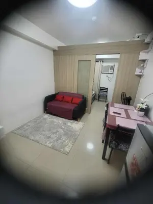 a living room with a red bed and a table at Apartment Condo Unit 1-br Self-contained in Manila