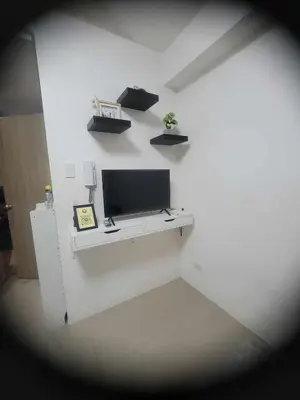 a white room with a tv on a white wall at Apartment Condo Unit 1-br Self-contained in Manila