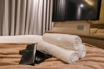 a pile of towels on a bed in a hotel room at cityscapethe39th at Eastwood Global Plaza - Luxury Residences in Manila