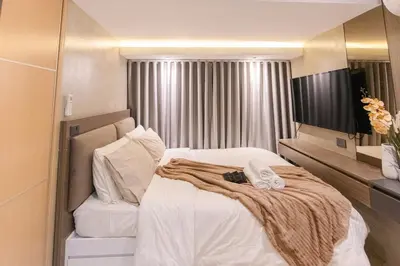 a bedroom with a large bed with white sheets at cityscapethe39th at Eastwood Global Plaza - Luxury Residences in Manila