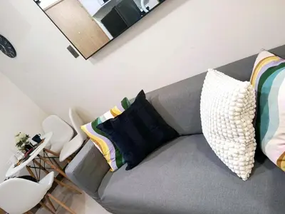 a living room with a gray couch with pillows at Brand New 2 Bedder near Malls SMDC Bloom in Manila
