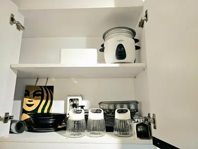 a kitchen shelf with some cups and dishes on it at Brand New 2 Bedder near Malls SMDC Bloom in Manila