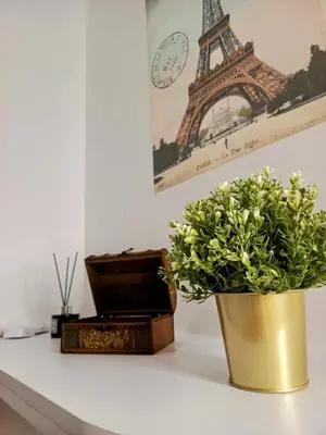 a vase with a plant on a table with the eiffel tower at Brand New 2 Bedder near Malls SMDC Bloom in Manila