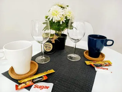 a table with two wine glasses and a vase with flowers at Brand New 2 Bedder near Malls SMDC Bloom in Manila