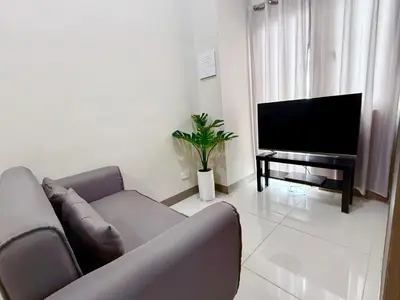 a living room with a couch and a flat screen tv at Coast Residences 40th Floor Penthouse Pasay Manila in Sampong