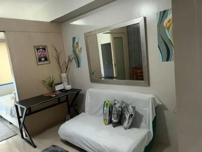 a white chair in a room with a mirror at Sea residence MOA KC PLACE in Manila