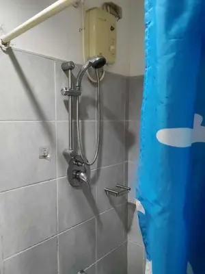a shower in a bathroom with a blue curtain at Sea residence MOA KC PLACE in Manila