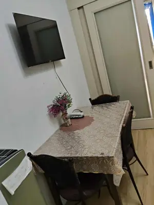 a table with chairs and a television on a wall at Sea residence MOA KC PLACE in Manila