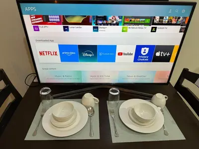 a table with plates and utensils and a computer screen at Pocco-breeze- inhouse pool in Manila