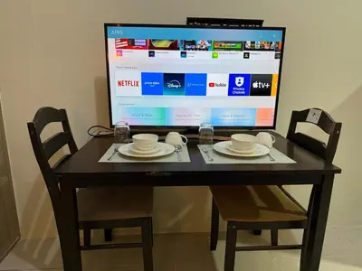 a table with two chairs and a large screen at Pocco-breeze- inhouse pool in Manila