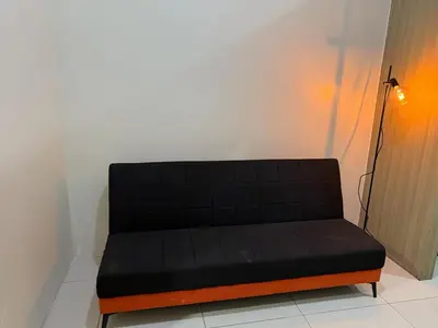 a black couch sitting in a room next to a wall at Pocco-breeze- inhouse pool in Manila