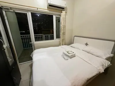a bedroom with a white bed with a window at Pocco-breeze- inhouse pool in Manila