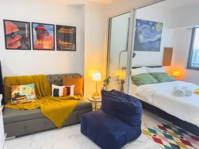 a bedroom with a bed and a couch and a chair at Unique and Quiet Studio Unit in Mandaluyong or Makati with Fast WiFi & Best City View in Manila