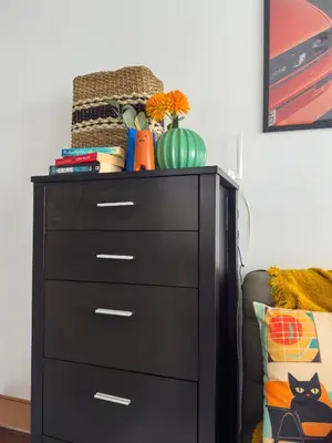 a black dresser with a vase on top of it at Unique and Quiet Studio Unit in Mandaluyong or Makati with Fast WiFi & Best City View in Manila