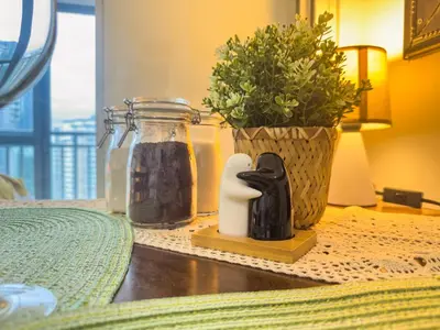 a table with a candle and a vase with a plant at Unique and Quiet Studio Unit in Mandaluyong or Makati with Fast WiFi & Best City View in Manila