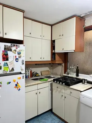a kitchen with white cabinets and a white refrigerator at Becca's double bedroom alongside Metrobank Makati in Manila