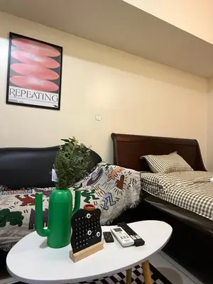 a living room with a bed and a table with a table at Pocco-breeze-moonlight in Manila