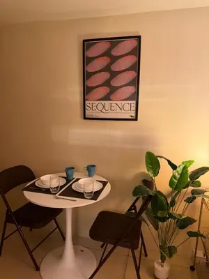 a table with two chairs and a picture on the wall at Pocco-breeze-moonlight in Manila
