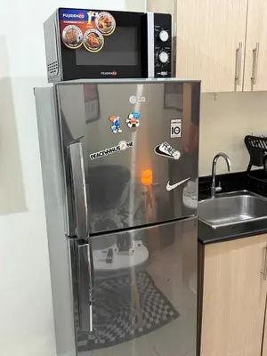 a refrigerator with a microwave on top of it at Pocco-breeze-moonlight in Manila