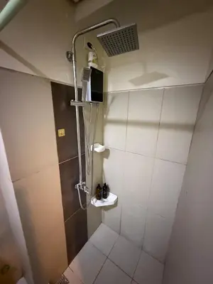 a bathroom with a shower with a toilet and a sink at Pocco-breeze-moonlight in Manila