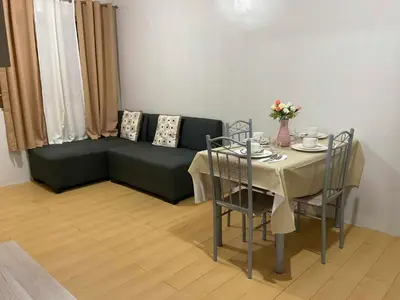 a living room with a green couch and a table at DBK HOMES Sorrento Oasis in Manila
