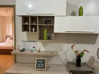 a kitchen with white cabinets and a table with a chalkboard at DBK HOMES Sorrento Oasis in Manila
