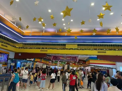 a crowd of people in a shopping mall with stars on the ceiling at Near MOA - Cozy Staycation 22D in Manila