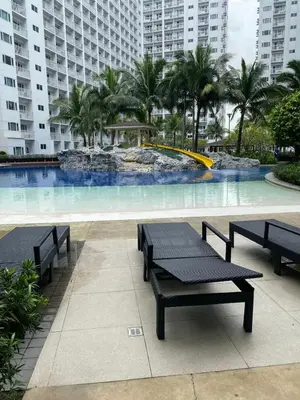 a pool with benches and a fountain in a building at Near MOA - Cozy Staycation 22D in Manila