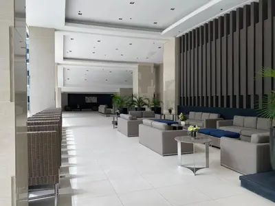 a lobby with couches and tables and a fireplace at Near MOA - Cozy Staycation 22D in Manila