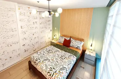 a bedroom with a bed and a wall with writing at Condo in BGC - Uptown Mall in Manila