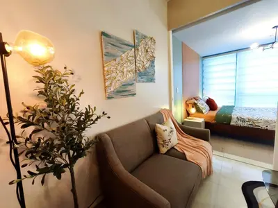 a living room with a couch and a bed at Condo in BGC - Uptown Mall in Manila