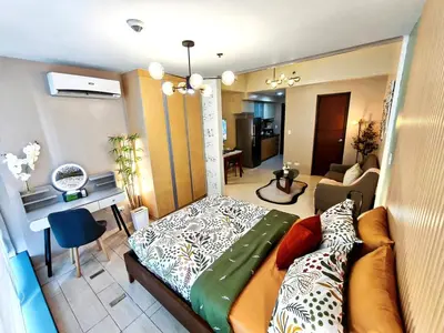 a small room with a bed and a living room at Condo in BGC - Uptown Mall in Manila