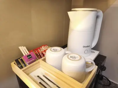 a coffee maker and two cups on a wooden tray at Condo in BGC - Uptown Mall in Manila