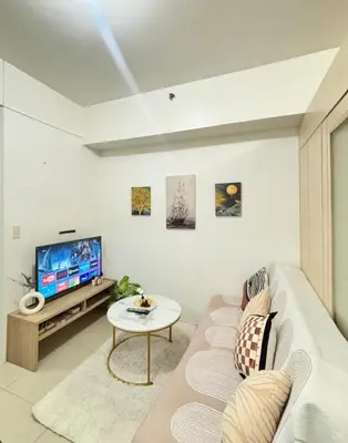 a living room with a couch and a tv at Your Urban Oasis in the Heart of Makati in Manila