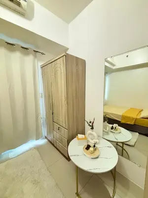 a room with two tables and a mirror and a bed at Your Urban Oasis in the Heart of Makati in Manila