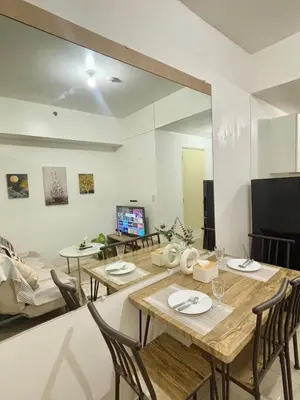 a living room with a table and chairs and a television at Your Urban Oasis in the Heart of Makati in Manila