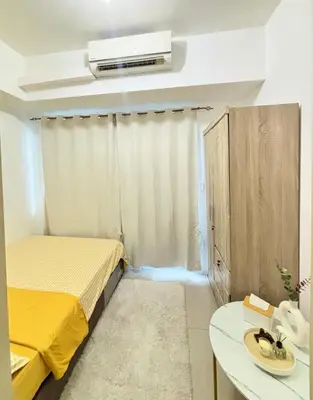 a small room with a bed and a table at Your Urban Oasis in the Heart of Makati in Manila